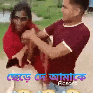 a man in a red shirt is holding a woman in his arms with picsart written on the bottom right