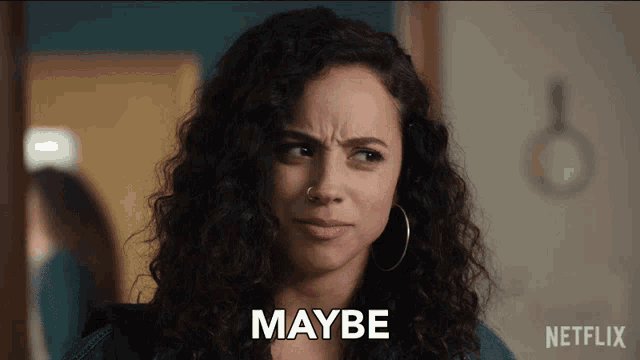 a woman with curly hair and a nose ring says maybe