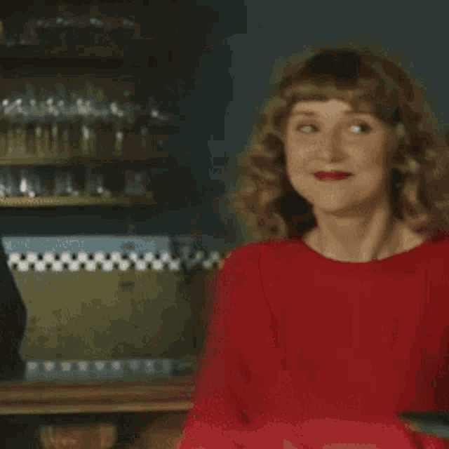 the woman is wearing a red sweater and red lipstick