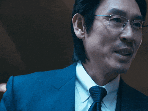 a man wearing glasses and a blue suit