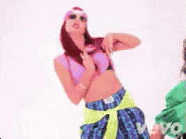a woman in a pink top and a green shirt is dancing