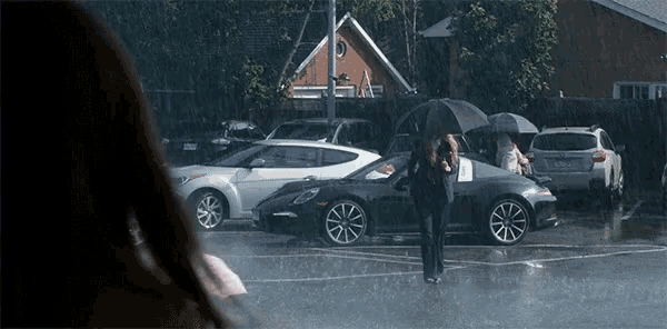 a woman holding an umbrella walking in the rain
