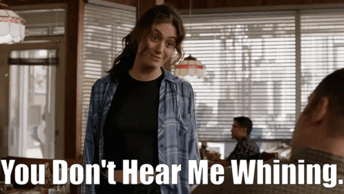 a woman in a blue plaid shirt says " you don 't hear me whining " to a man