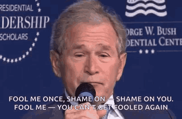 george bush is holding a microphone in front of a sign that says fool me once , shame on