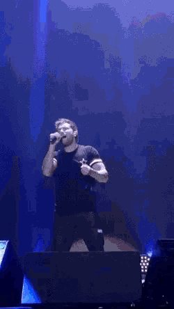 a man is singing into a microphone on stage