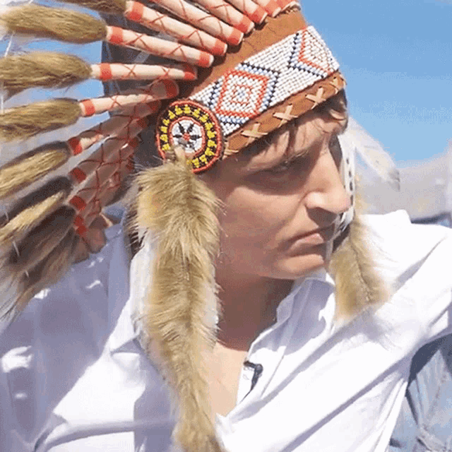 a man wearing a native american headdress with feathers on it