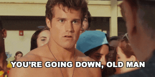 a shirtless man says " you 're going down old man " in front of a group of people