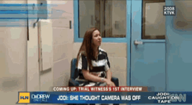 a woman sits in a chair in front of a cnn news report