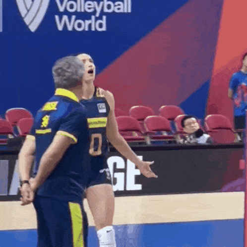 a volleyball player with the number 0 on her jersey is talking to a coach