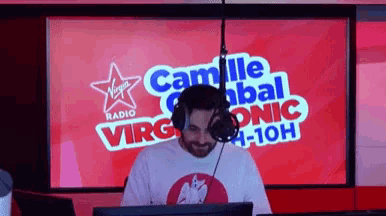 a man stands in front of a virgin radio screen
