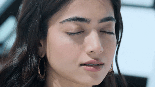 a close up of a woman 's face with her eyes closed and her mouth open