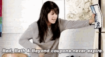 a woman is standing in front of a refrigerator holding a coupon that says bed bath and beyond coupons never expire