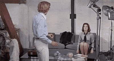 a man is standing next to a woman on a couch .