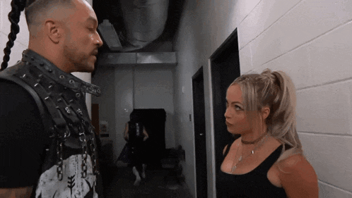 a man and a woman are looking at each other in a hallway .