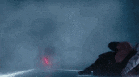 a silhouette of a man walking in a dark room with a sword .