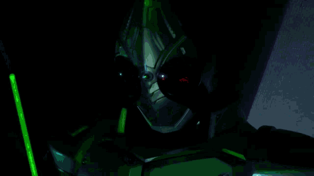a green light is shining on the face of a robot