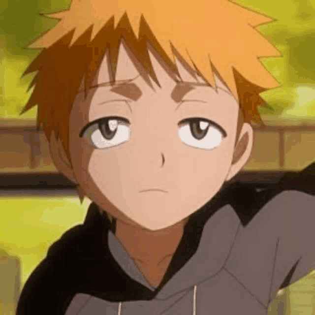a close up of a young boy with orange hair and a gray shirt .