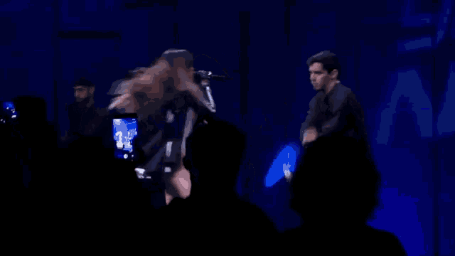 a man taking a picture of a woman on stage