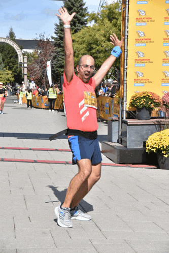 a man is standing in front of a marathon banner