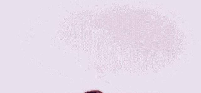 a woman in a white jumpsuit is dancing in front of a pink background .