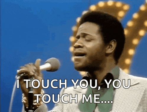 a man singing into a microphone with the words " i touch you you touch me "