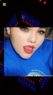 a woman wearing a blue shirt that says i 'll blow your door sticks her tongue out