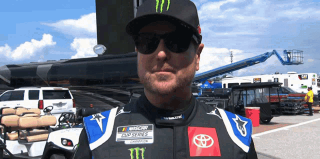 a man wearing a nascar outfit and sunglasses