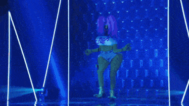 a drag queen is dancing on a stage with a reflection of her in the water