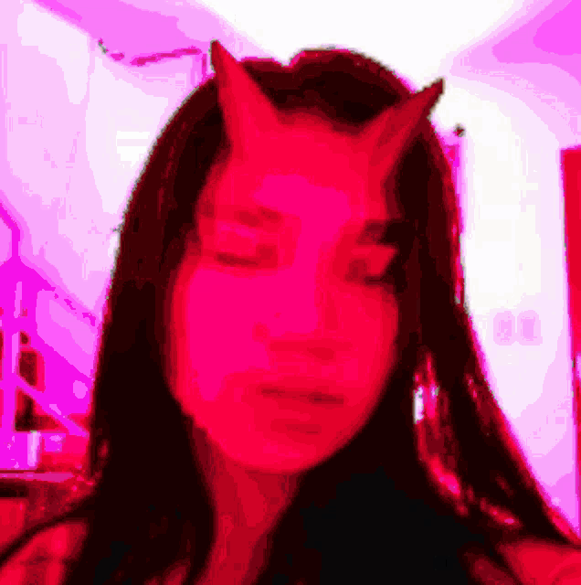 a woman with devil horns on her head is taking a selfie