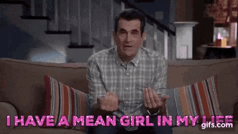 a man in a plaid shirt is sitting on a couch and says `` i have a mean girl in my life '' .