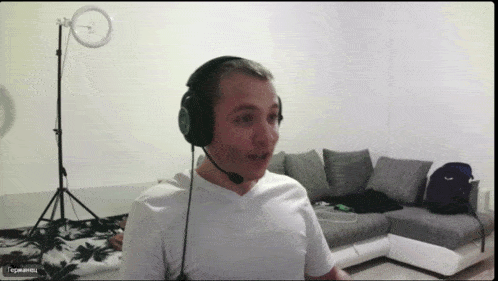 a man wearing headphones and a microphone has a facebook logo on the bottom right of his screen