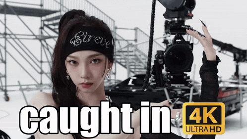a woman is holding a camera with the words caught in 4k ultra hd