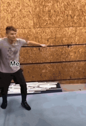 a man in a grey shirt is jumping in a boxing ring with the word me written on the bottom