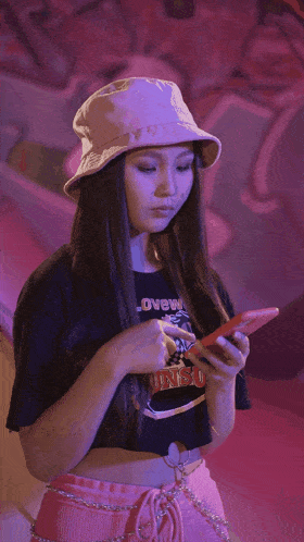 a woman wearing a pink hat and a crop top that says ' disney ' on it