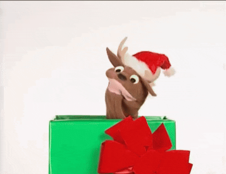a stuffed reindeer wearing a santa hat is sticking its head out of a green box .