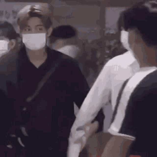 a man wearing a mask is holding another man 's hand while walking .