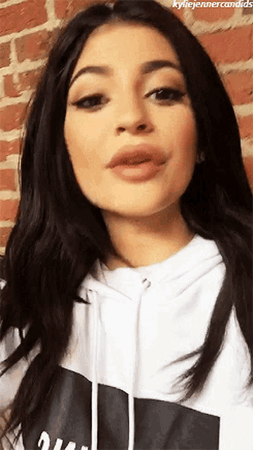 a close up of a woman 's face with the words kylie jenner candids at the top