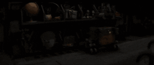 a dark room with a shelf filled with lots of items