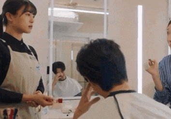 a woman is talking to a man in front of a mirror in a bathroom .