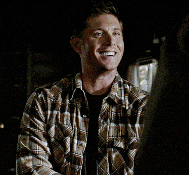 a man in a plaid shirt talking to another man