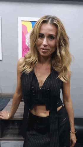 a woman in a black crop top and striped vest