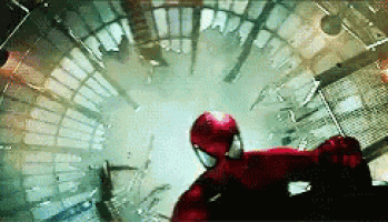 a man in a red spiderman suit is flying through the air in a building .