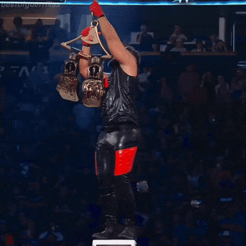 a man in a black and red outfit is holding a trophy in his hand