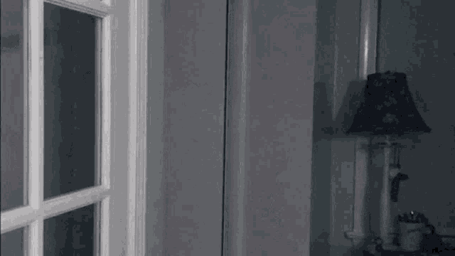 a lamp is sitting on a table next to a door .