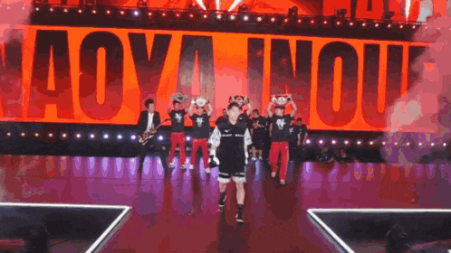 a group of people holding trophies on a stage in front of a sign that says " aoy inou "