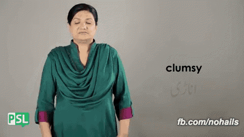 a woman in a green shirt is making a clumsy sign .
