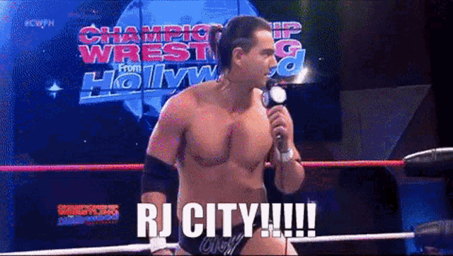 a man in a wrestling ring is holding a microphone and says " rj city "
