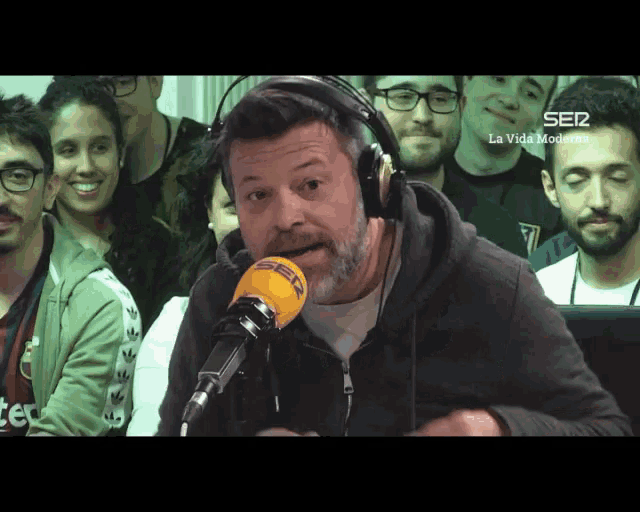 a man wearing headphones stands in front of a microphone with the word ser on it