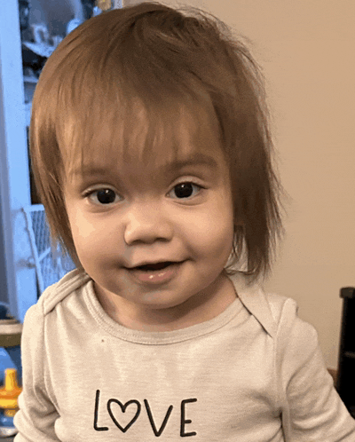a baby wearing a white shirt that says love on it