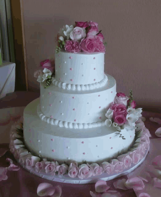 a white wedding cake with pink and white flowers